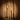 Five lit, Hall of Flame Venti Brown long Taper Candles sit in a spotlight, slightly melted.