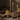 Four lit Hall of Flame Bordeaux Dark Red Wax Candle Holders made from sustainable plant-based wax stand among braided bread and iced pastries on a white tablecloth, bathed in warm, soft light. Burn time details appear at the bottom.
