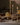Four lit Hall of Flame Bordeaux Dark Red Wax Candle Holders made from sustainable plant-based wax stand among braided bread and iced pastries on a white tablecloth, bathed in warm, soft light. Burn time details appear at the bottom.