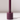The Hall of Flame Jam Purple Wax Candle Holder features a cylindrical design with a central vertical rod, ideal for sustainable plant-based pillar candles. It casts a soft shadow on white surfaces against light backgrounds.