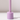 The Hall of Flame Wisteria Purple Wax Candle Holder stands upright on a white surface, its minimalist design casting a shadow to the right against an uncluttered, light background.