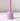 The Hall of Flame Wisteria Purple Wax Candle Holder stands upright on a white surface, its minimalist design casting a shadow to the right against an uncluttered, light background.