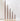 Chocolate Brown Taper Candles, varying in height, are lined up from tallest to shortest in gold candle holders.