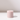 The Hall of Flame Ballet Pink Wax Candle Holder, a sustainable pastel pink cylinder with a central hole, sits on a white surface casting a soft shadow rightward against a light background.