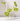 Five white candles in the Hall of Flame Glass Crystal Candelabra are accented with five green anthurium stems, all set against a plain white backdrop.