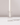 A white candle stands upright in a rectangle Crystal Glass Candle Holder.