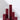 Six Hall of Flame Bordeaux Dark Red burgundy Square Pillar Candles are clustered on a white surface, their burgundy colour.