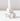 A close-up of the Hall of Flame White Flower Candle Holder, featuring ruffled petal details and crafted with advanced 3D print technology, holds a white candle against a plain white background.