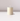 A single unlit Hall of Flame Ivory Votive Candle from a 10-pack rests on a glossy white surface, set against a light gray background.