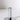 The Hall of Flame Silver Plated Candle Holder stands upright on a white surface, its sleek cylindrical design and flat base casting a subtle shadow—a minimalistic accent designed for XXL Tapers.