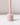 The Hall of Flame Ballet Pink Wax Candle Holder, made from sustainable plant-based wax in a pale pink cylindrical design with a vertical rod, stands on a white surface and casts a soft shadow against a plain light background.