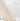 Twelve cream-colored XXL taper candles from the Hall of Flame Collection 4 | Pre-styled Bundle are arranged by height in gold holders, ideal for elegant wedding styling against a plain white background.