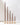 Chocolate Brown Taper Candles, varying in height, are lined up from tallest to shortest in gold candle holders.