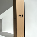 A tall Hall of Flame box labeled Bulk Candles - Wholesale box stands upright beside a single slender black candle.