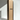 A tall Hall of Flame box labeled Bulk Candles - Wholesale box stands upright beside a single slender black candle.