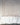 A long table set with clear glass plates, gold cutlery, and Hall of Flames Collection 2 Pre-styled Bundle (18 XXL taper candles) in glass holders creates a minimalist, elegant wedding look against a white arched wall.