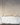 A spacious room features a long table with white florals, clear glassware, minimal tableware, and Hall of Flames Collection 6 | Pre-styled Bundle (8 Candles) in gold holders. Perfectly elegant for wedding table styling against a white arched wall.