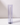 A Hall of Flame Blue Coloured Glass Sleeve holds a tall candle upright on a white surface, set against a light gray background.