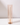 A tall, white taper candle stands upright in a Hall of Flame Nude Coloured Glass Sleeve, adding a modern touch to classic holders. Displayed on a white surface against a simple background.
