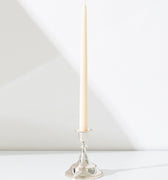 A tall, ivory taper candle in the Hall of Flame Silver Antique candle holder.