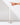 A hand reaches toward the unlit wick of a Hall of Flame White | Realistic LED Flameless Taper Candle, which stands upright in a shiny silver holder against a plain white background.