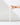 A hand gently touches the top of a Hall of Flame White Realistic LED Flameless Taper Candle, standing upright on a white surface against a white background.