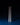 Two white SAMPLE SALE | LED Candles by Hall of Flame stand side by side on a blue surface against a dark background, casting long shadows behind them.