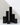 Six Hall of Flame Black Square Pillar Candles XXL in varying heights are arranged in a minimalist city skyline effect.