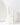 Hall of Flame’s Wedding Pillar Package features 42 white, hand-poured pillar candles of varying heights, arranged on a white surface for a minimalist and serene effect with soft lighting.
