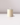 A single unlit Hall of Flame Ivory Votive Candle from a 10-pack rests on a glossy white surface, set against a light gray background.