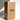 A tall beige candle stands beside a large brown Hall of Flame box labeled Bulk Candles | Wholesale by-the-box with upward arrows and THIS WAY UP, illuminated by natural light from the left.
