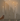 A hand holds a Hall of Flame Remote for Ultra-Bright LED Taper Candles near a silver candelabra with two lit white LED candles, set against a plain light-colored background.