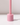 The Hall of Flame Petal Pink Wax Candle Holder features a cylindrical, glossy design with smooth edges. It stands on a white surface with a vertical rod, casting a soft shadow and offering minimalist elegance.