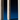 Close-up of a cream ULTRABRIGHT™ LED Flameless Taper Candle by Hall of Flame standing upright on a blue surface against a dark background, with "Hall of Flame" embossed vertically.