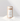 A cylindrical kraft paper container labeled SANDWAX Scented Candle Refill by Hall of Flame stands upright on a white surface with small piles of white powder. Its minimalist label features a line drawing of a candle and the scent FIG BOIS.