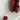 Four burgundy square candles of varying heights sit unlit on a glossy white Acrylic Candle Drip Tray by Hall of Flame near a wall, their reflections visible on the tray’s surface.