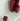 Four burgundy square candles of varying heights sit unlit on a glossy white Acrylic Candle Drip Tray by Hall of Flame near a wall, their reflections visible on the tray’s surface.