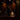 Two people in suits stand on a wooden stage with a drum set and piano nearby. Hall of Flame ULTRABRIGHT™ LED Flameless Taper Candles are arranged in front, creating a warm, intimate atmosphere without open flames.